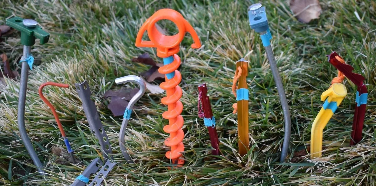 Various types of tent stakes laid out showing the different designs and materials available for camping